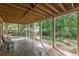 Covered patio with stone flooring, white columns, and peaceful views of the landscaped garden at 180 Winecoff Dr, Fayetteville, GA 30214