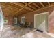 Spacious covered patio with stone flooring, brick walls, and a view of the lush backyard at 180 Winecoff Dr, Fayetteville, GA 30214