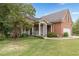 Brick home with a welcoming front porch, lush lawn, and side-entry garage at 180 Winecoff Dr, Fayetteville, GA 30214
