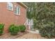 Exterior view of brick home with wooden stairs leading to upper level and view of beautiful, landscaped yard at 180 Winecoff Dr, Fayetteville, GA 30214
