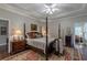 Bright main bedroom featuring a four-poster bed, lamps and a large rug with hardwood floors at 180 Winecoff Dr, Fayetteville, GA 30214