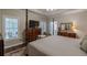Bright main bedroom featuring a bed, tv on bureau and a sitting chair with natural light streaming in at 180 Winecoff Dr, Fayetteville, GA 30214