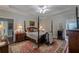 Bright main bedroom featuring a four-poster bed, lamps and a large rug with hardwood floors at 180 Winecoff Dr, Fayetteville, GA 30214