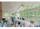 Relaxing screened porch with brick wall, ceiling fans, comfortable seating, and views of lush trees and green grass at 180 Winecoff Dr, Fayetteville, GA 30214