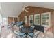 Inviting screened porch with brick wall, ceiling fans, ample seating, and views of the surrounding greenery at 180 Winecoff Dr, Fayetteville, GA 30214