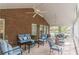 Comfortable screened porch with brick wall, ceiling fans, ample seating, and view of the surrounding greenery at 180 Winecoff Dr, Fayetteville, GA 30214