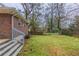 View of the backyard, featuring a brick house, steps, and trees at 1561 Rupert Rd, Decatur, GA 30032