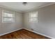 Simple bedroom featuring hardwood floors, neutral walls, and natural light from two windows at 1561 Rupert Rd, Decatur, GA 30032