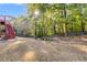 Wide shot of the backyard showing mature trees and partial fence at 315 Hunters Trce, Dallas, GA 30157