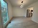 Bright dining area featuring light wood floors, a modern light fixture, and a large window overlooking the front yard at 3663 Heatherwood Ne Dr, Marietta, GA 30066