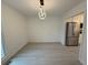 Bright dining area featuring light wood floors, a modern light fixture, and an open doorway to the kitchen at 3663 Heatherwood Ne Dr, Marietta, GA 30066