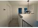 Hallway with a modern light fixture, grey handrail, and doors leading to other rooms at 3663 Heatherwood Ne Dr, Marietta, GA 30066