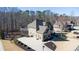 Aerial view of a tan two story home with a large driveway, three car garage, and landscaped yard at 4095 Copper Leaf Ln, Cumming, GA 30040