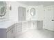 Bright bathroom features stylish patterned tile floors, double vanity with mirrors, and ample cabinet storage at 4095 Copper Leaf Ln, Cumming, GA 30040