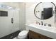 Bathroom featuring a glass-enclosed tiled shower, a modern vanity with a round mirror, and shiplap wall accents at 4095 Copper Leaf Ln, Cumming, GA 30040