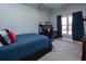 Bedroom with blue quilt on the bed, a desk, and a window with long blue curtains at 4095 Copper Leaf Ln, Cumming, GA 30040