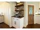 Convenient coffee bar featuring shelving, a cabinet, and an espresso machine located just off the main kitchen space at 4095 Copper Leaf Ln, Cumming, GA 30040