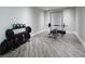 Home gym featuring a weight rack with weights and kettlebells, a bench with barbell rack and gray wood-look floors at 4095 Copper Leaf Ln, Cumming, GA 30040