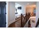 Bright hallway features a decorative wooden railing and leads to an open, elevated seating area with large screen TV at 4095 Copper Leaf Ln, Cumming, GA 30040