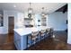 Spacious kitchen featuring a large island with seating for five, stainless steel appliances, and stylish pendant lighting at 4095 Copper Leaf Ln, Cumming, GA 30040