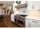 Well-equipped kitchen featuring a stainless steel Wolf range and hood, complemented by white cabinets and subway tile backsplash at 4095 Copper Leaf Ln, Cumming, GA 30040