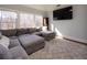 Bright living room features a large sectional sofa, oversized windows offering great natural light, and wall-mounted TV at 4095 Copper Leaf Ln, Cumming, GA 30040
