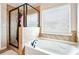Bathroom featuring soaking tub, glass shower, and window with blinds at 2600 Reece Farms Sw Trl, Powder Springs, GA 30127