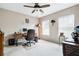 Bright bedroom features a ceiling fan, two windows, and a wooden desk at 2600 Reece Farms Sw Trl, Powder Springs, GA 30127