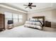 Spacious bedroom featuring a tray ceiling, ceiling fan, and large window at 2600 Reece Farms Sw Trl, Powder Springs, GA 30127