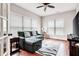 Comfortable bonus room with hardwood floors, large windows, and a plush gray sofa at 2600 Reece Farms Sw Trl, Powder Springs, GA 30127