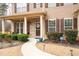 Inviting front porch with brick accents, a decorative wreath, and well-maintained landscaping at 2600 Reece Farms Sw Trl, Powder Springs, GA 30127