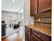 Convenient butler's pantry includes granite countertop and rich wood cabinetry between the living room and kitchen at 2600 Reece Farms Sw Trl, Powder Springs, GA 30127