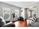 Bright living room with hardwood floors, comfortable seating, and a large window at 2600 Reece Farms Sw Trl, Powder Springs, GA 30127