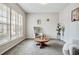 Cozy living room with large windows, neutral carpet, and a round wooden coffee table at 2600 Reece Farms Sw Trl, Powder Springs, GA 30127