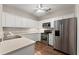 Bright kitchen with stainless steel refrigerator, oven, microwave, white cabinets, and solid surface countertops at 420 Copeland St, Grayson, GA 30017