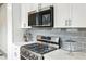 Modern kitchen features stainless steel appliances, gray backsplash, and white cabinetry at 49 Wyman Se St, Atlanta, GA 30317