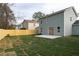 Back of home with a wood privacy fence, green lawn, and access to the backyard via french doors at 6242 Marbut Farms Ln, Lithonia, GA 30058