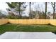 Spacious backyard featuring a well-maintained lawn, newly planted bushes, and a concrete patio at 6242 Marbut Farms Ln, Lithonia, GA 30058