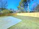 Open backyard, featuring a new concrete patio pad, and wooden privacy fence at 6242 Marbut Farms Ln, Lithonia, GA 30058