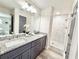 Elegant bathroom featuring double sink vanity, granite counters, and tiled shower at 6242 Marbut Farms Ln, Lithonia, GA 30058