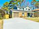 Inviting two-story home with a well-maintained lawn and concrete driveway leading to a garage at 6242 Marbut Farms Ln, Lithonia, GA 30058