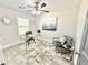 Bright home office featuring glass desk, neutral walls, ceiling fan, and stylish decor at 6242 Marbut Farms Ln, Lithonia, GA 30058