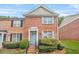 Charming two-story brick townhouse with well-manicured front yard and light blue shutters at 1976 Drennon Ave, Austell, GA 30106