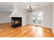 A cozy living room features hardwood floors, a fireplace, a chandelier, and double doors at 3263 Tomeh Way, Tucker, GA 30084