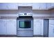 Close up of the range and dishwasher in the kitchen with white cabinets at 3736 Soapstone Rd, Decatur, GA 30034
