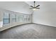Spacious bedroom with carpet flooring, fan, and multiple windows for natural light at 405 Sora Dr, Stockbridge, GA 30281