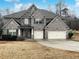 Charming two-story brick home with a well-manicured lawn and a two-car garage at 405 Sora Dr, Stockbridge, GA 30281