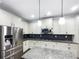Modern kitchen featuring stainless steel appliances, granite countertops, and stylish pendant lighting at 405 Sora Dr, Stockbridge, GA 30281