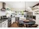 Well-lit kitchen showcases modern appliances, custom shelving, and a functional dining space at 1015 Loliver Ln, Chattahoochee Hills, GA 30268
