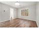 This bright bedroom features wood-look flooring, neutral walls, a ceiling light, and a window view at 1534 Norman Xing, Atlanta, GA 30349
